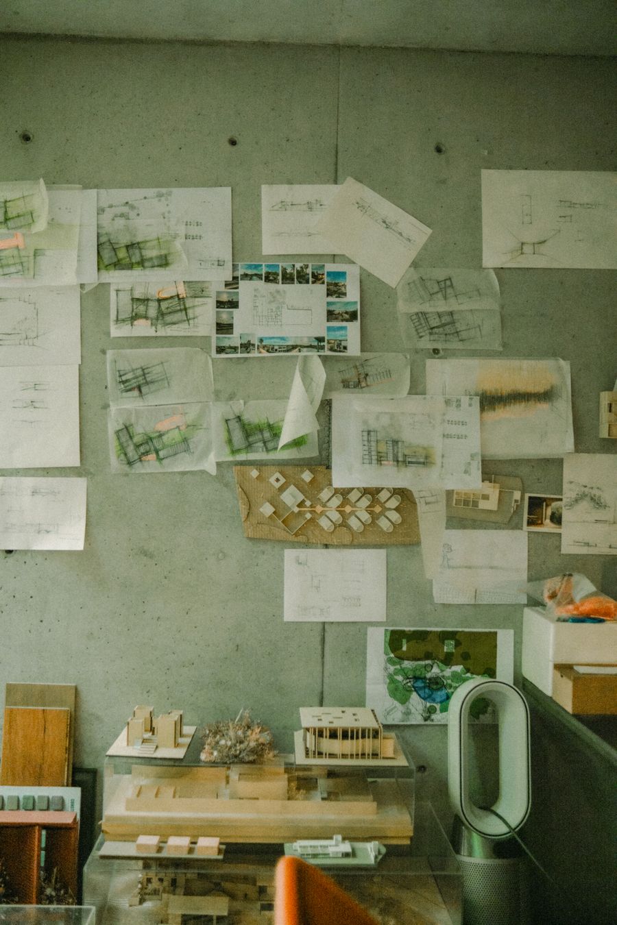 Studio wall covered in architectural sketches above scale models